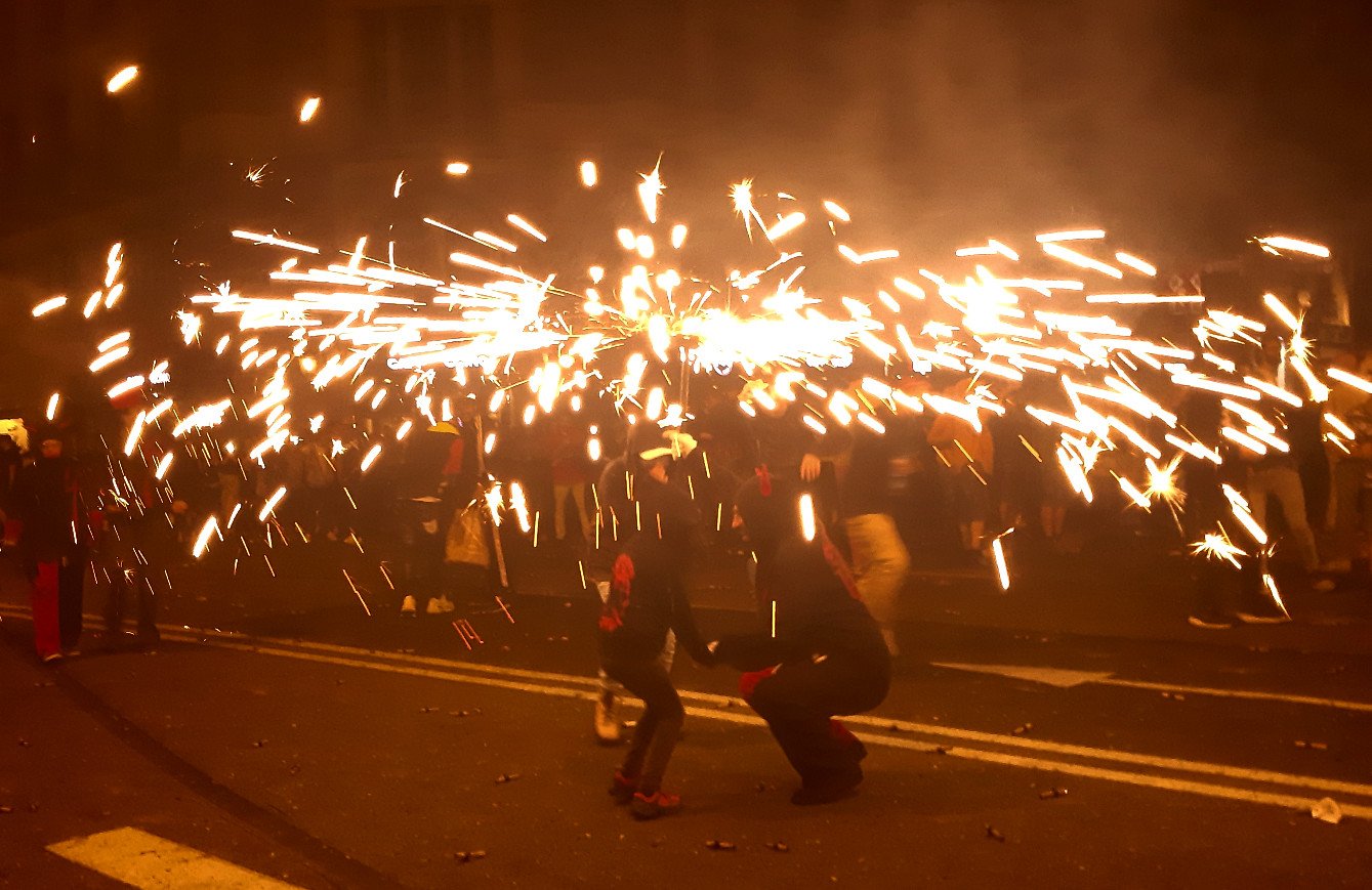 Correfoc nocturno en la Via Laietana de Barcelona: diables con bestiari y lluvia de chispas en plena fiesta