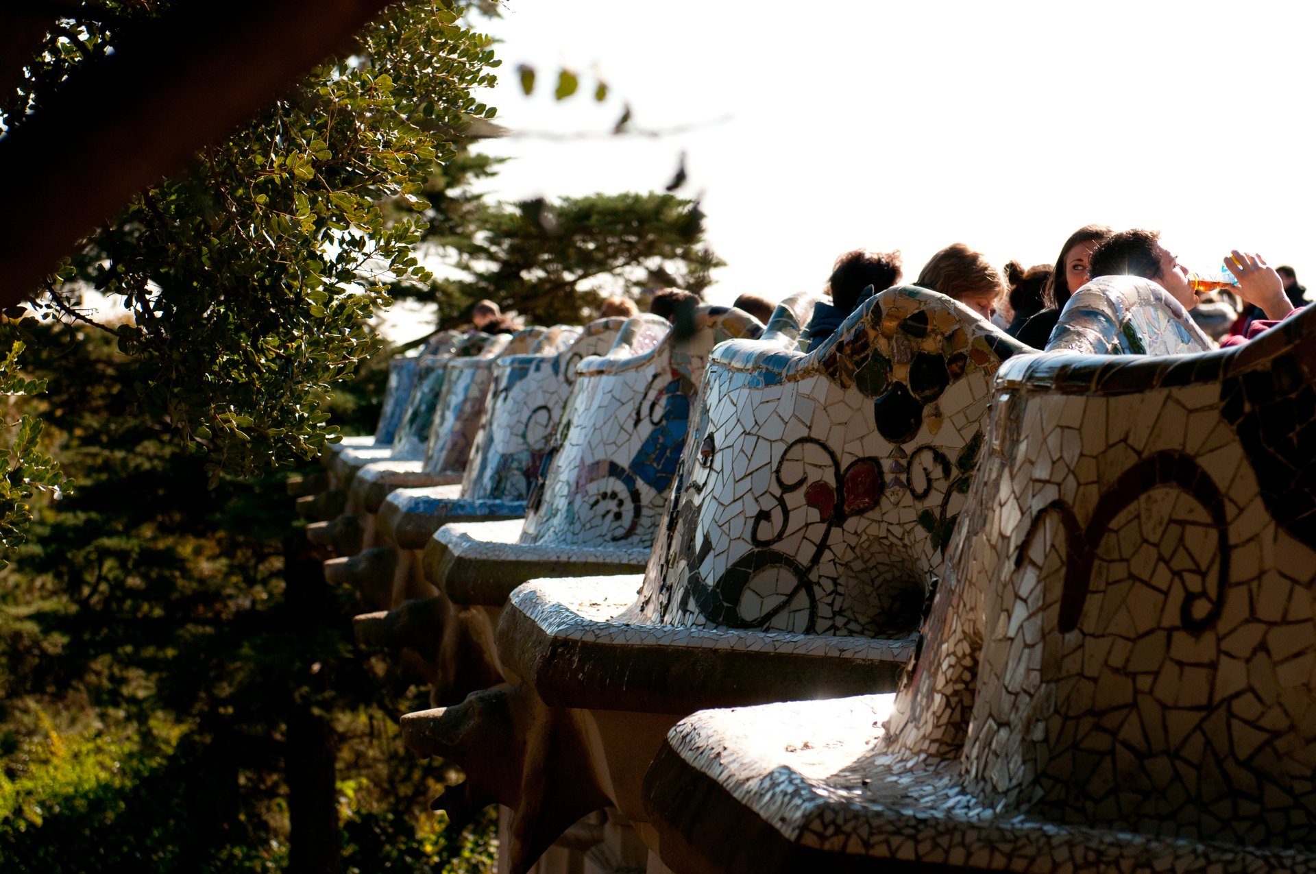 Banco serpenteante del Park Güell revestido de trencadís en la Gran Plaza, con vistas panorámicas sobre Barcelona