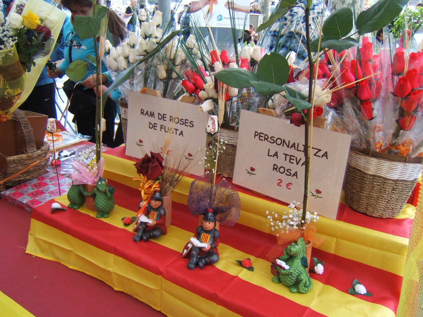 Parada de rosas de Sant Jordi con carteles que ofrecen personalizar la rosa